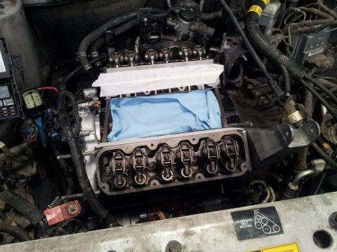 2001 Chevrolet Impala - Engine bay with valve covers removed, revealing internal components and a protective cloth.