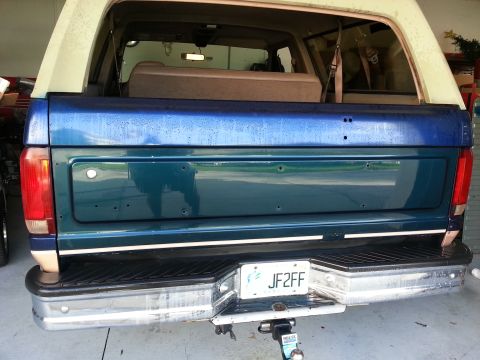 1994 Ford Bronco - The rear of an SUV is shown, a two-tone paint scheme and a trailer hitch.