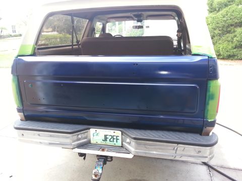 1994 Ford Bronco - The rear of a blue Ford Bronco, showing its tailgate and bumper with a Florida license plate.