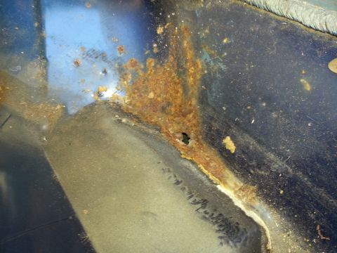 1994 Ford Bronco - This image shows significant rust and corrosion on a vehicle's metal panel, indicating potential structural damage.