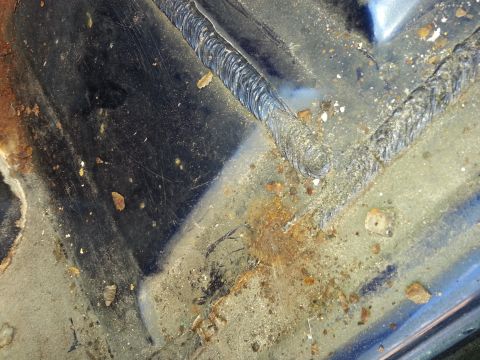 1994 Ford Bronco - The underside of a vehicle's floor shows signs of rust and recent welding work.