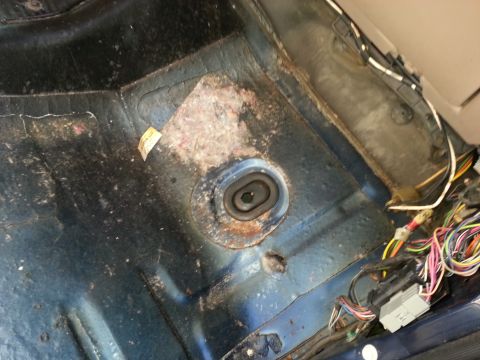 1994 Ford Bronco - The interior floor pan shows signs of rust and exposed electrical wiring, indicating potential repair needs.