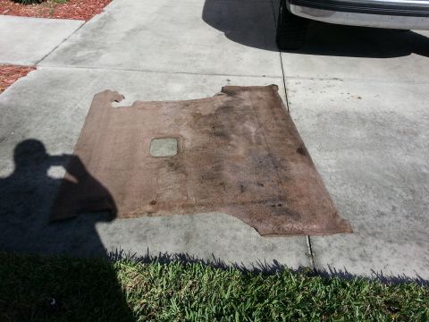 1994 Ford Bronco - Car floor carpet removed and placed on a concrete surface.
