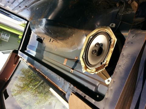 1994 Ford Bronco - Interior view of a car door panel with a speaker and visible rust.