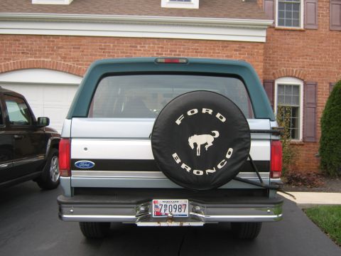 1996 Ford Bronco - The rear of a 1996 Ford Bronco is visible, a spare tire cover with the model name and emblem.