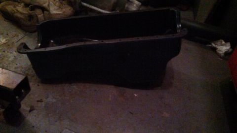 1979 Ford Bronco - This black oil pan is shown on a concrete floor, likely in a garage or workshop setting.