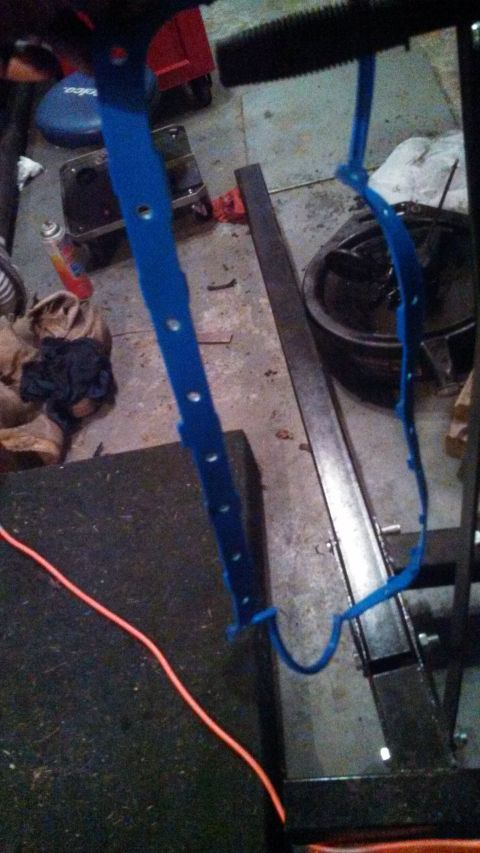 1979 Ford Bronco - A blue metal part with holes is visible in a workshop setting.