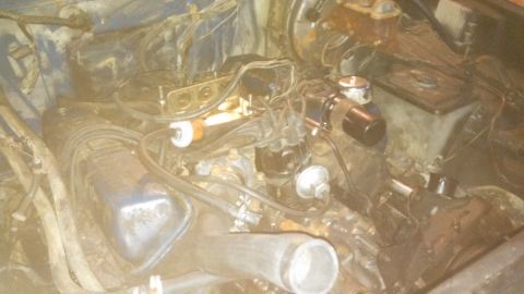 1979 Ford Bronco - The engine bay of a vehicle is shown with various components and wiring.