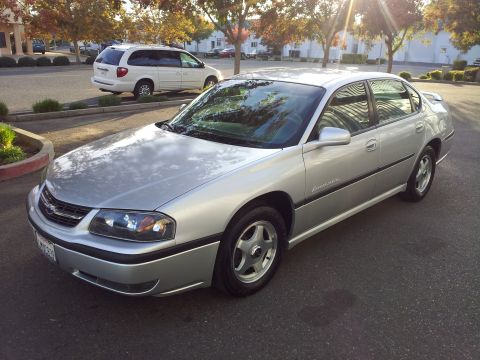2001 Chevrolet Impala - Silver Chevrolet sedan parked on asphalt with a white minivan in the background.
