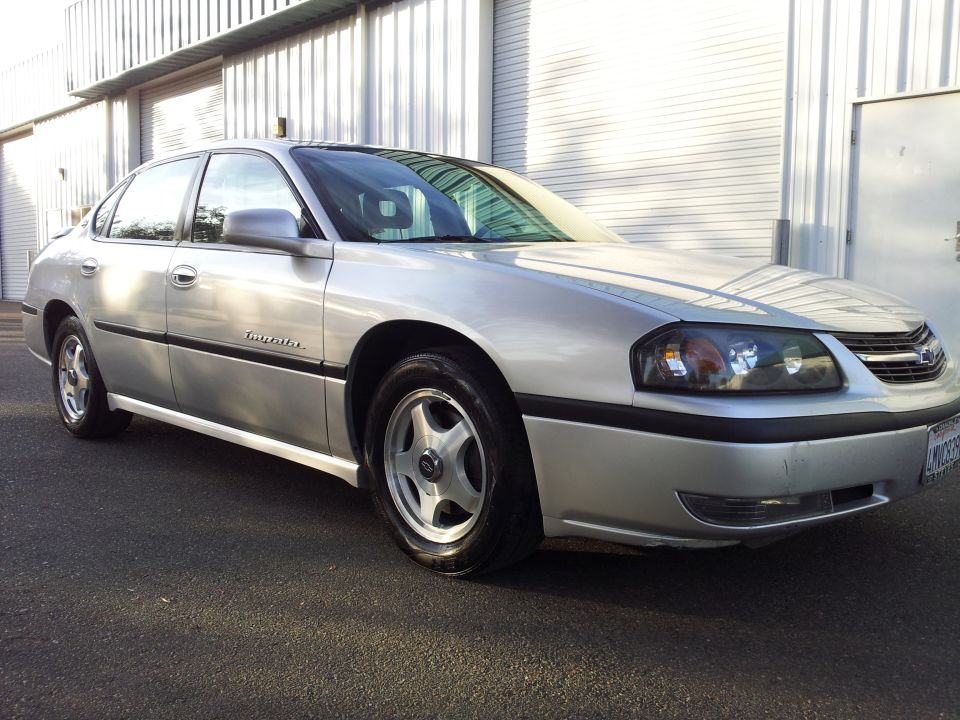 Silver 2001 Chevrolet Impala parked outside a building