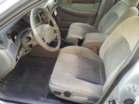 2001 Chevrolet Impala - The interior of a 2000 Chevrolet Impala shows tan cloth seats, dashboard, and steering wheel.