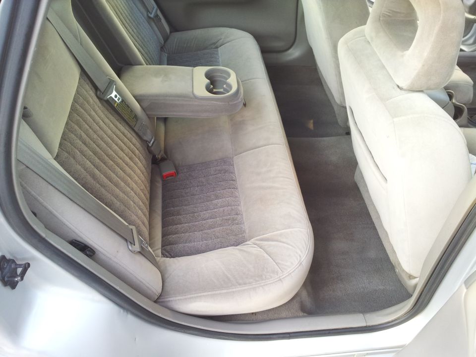Rear interior of a 2001 Chevrolet Impala showing cloth seats and cup holder