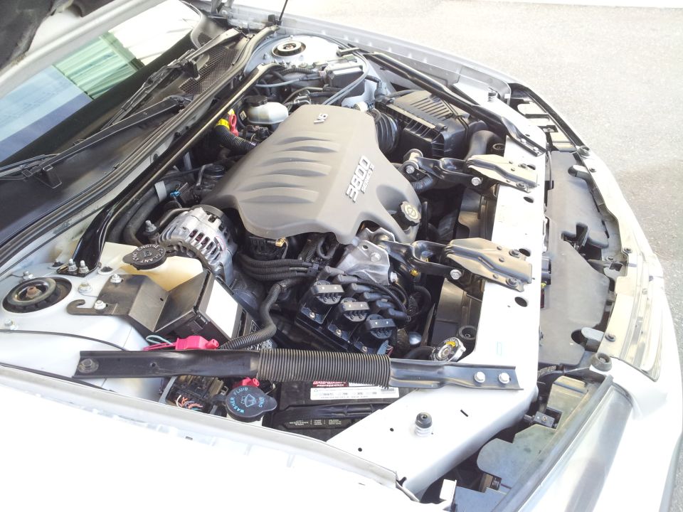 Engine bay of silver sedan with 3800 V6 engine and plastic intake cover