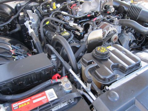 2001 Ford Crown Victoria - Close-up view of a vehicle's engine bay, showing the battery, fuse box, and various engine components.