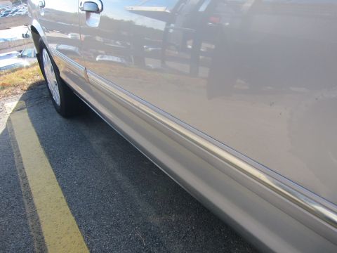 2001 Ford Crown Victoria - Side view of a silver 2001 Ford Crown Victoria, showing the door panel and front wheel.