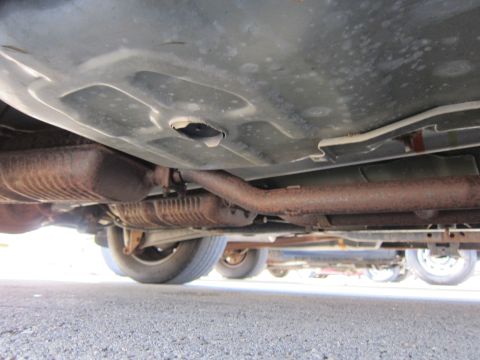 2001 Ford Crown Victoria - The underside of a vehicle is visible, with exhaust components and a fuel tank. Another vehicle is partially seen below.