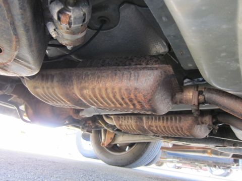 2001 Ford Crown Victoria - Undercarriage view shows a rusty exhaust system and catalytic converter, with no visible year identification.
