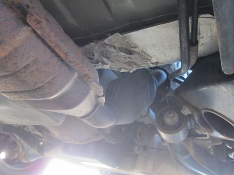 2001 Ford Crown Victoria - Close-up of vehicle undercarriage, focusing on exhaust pipes and suspension parts.