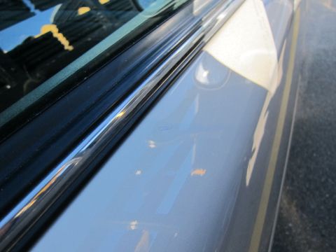 2001 Ford Crown Victoria - Detail shot of a car's side trim, reflecting the sky and surroundings.