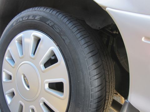 2001 Ford Crown Victoria - Wheel and tire detail on a 2001 Ford Crown Victoria, showing the Ford emblem and tire tread.