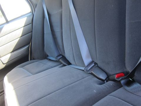 2001 Ford Crown Victoria - Interior view of a car's rear seat, showing the seat belts and fabric upholstery.
