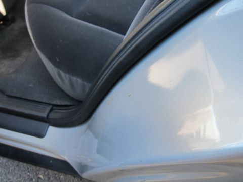 2001 Ford Crown Victoria - Close-up view of the interior door frame and seat of a silver car.