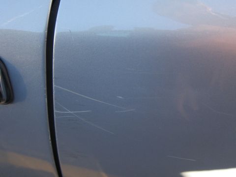 2001 Ford Crown Victoria - Scratches are visible on the side panel of a light blue vehicle.