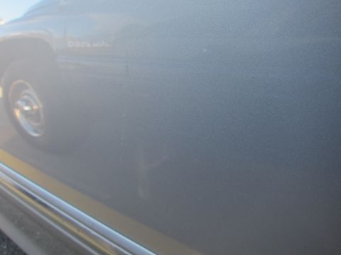 2001 Ford Crown Victoria - Close-up of a Dodge Ram truck's side panel, revealing minor imperfections in the paintwork.