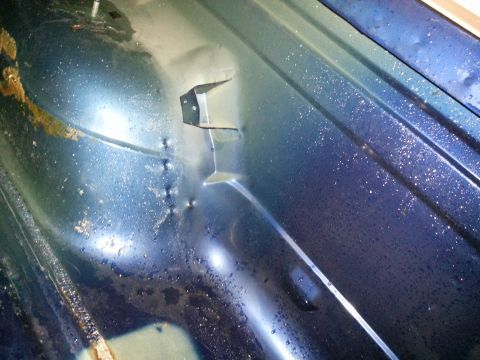 1994 Ford Bronco - The interior of a vehicle shows a blue metal panel with signs of wear and moisture.