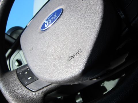 2001 Ford Crown Victoria - Close-up of a Ford steering wheel, showing the airbag cover and controls.