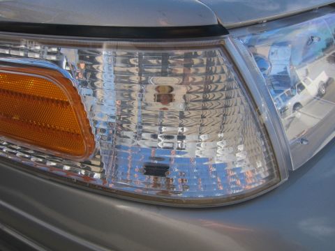 2001 Ford Crown Victoria - Close-up of the front headlight assembly on a silver 2001 Ford Crown Victoria.