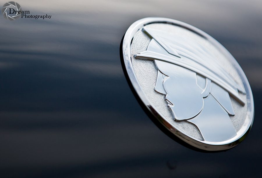 Close-up of 2003 Mercury Marauder emblem on dark car body. Supermotors.net logo visible