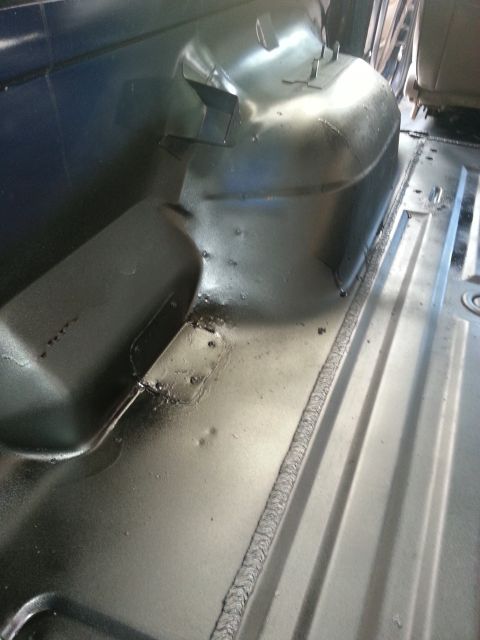 1994 Ford Bronco - Close-up view of the vehicle's interior floor pan and wheel well, highlighting metal fabrication.