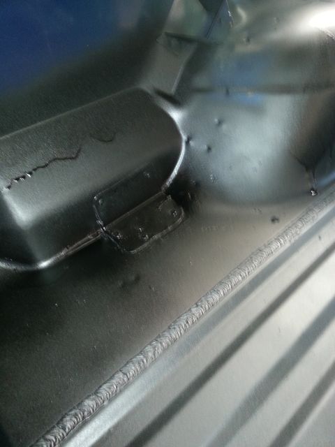 1994 Ford Bronco - The underside of a vehicle's interior floor pan shows signs of repair and construction.