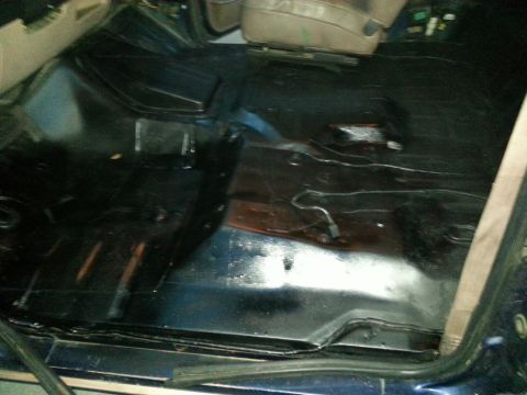 1994 Ford Bronco - The bare metal floor of a vehicle's interior, with visible wiring and some discoloration.