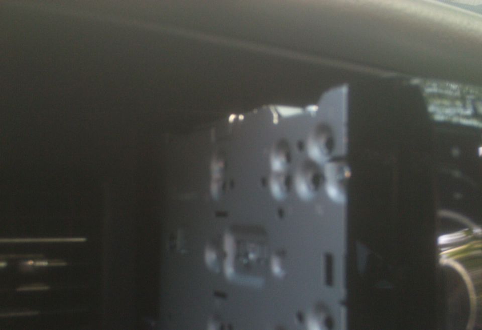 Rear view of a car stereo's wiring harness and mounting bracket