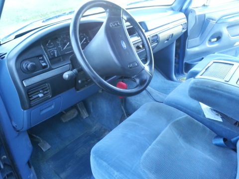 1994 Ford F-250 - The interior of a blue truck, a dashboard and steering wheel, with a watermark at the bottom right.