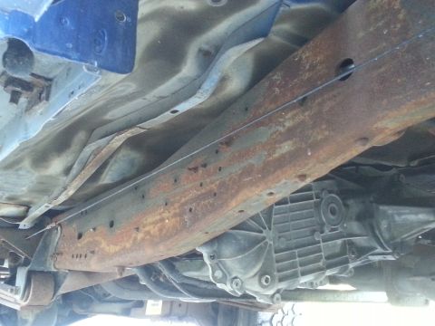 1994 Ford F-250 - Close-up of the undercarriage, showing the frame and transmission components of a truck.