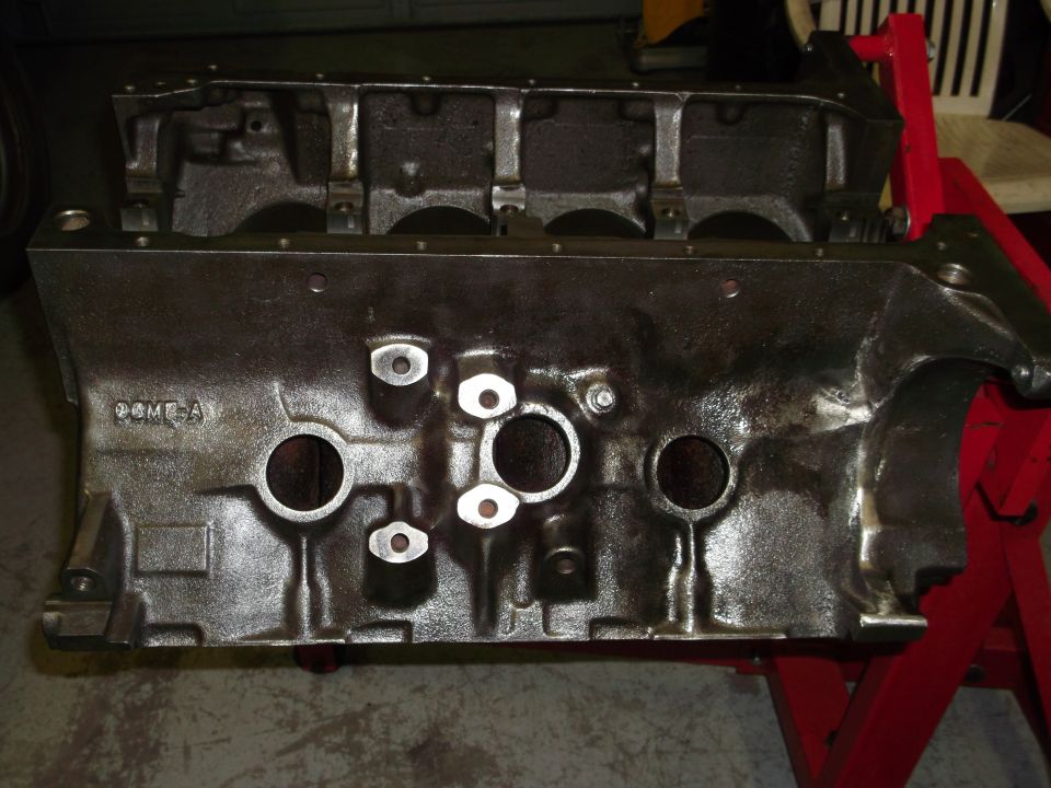 Cast iron engine block with "COME-A" casting mark, on red engine stand