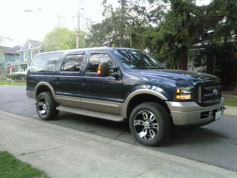 2005 Ford Excursion - Dark blue and tan 2005 Ford Excursion parked on a residential street.
