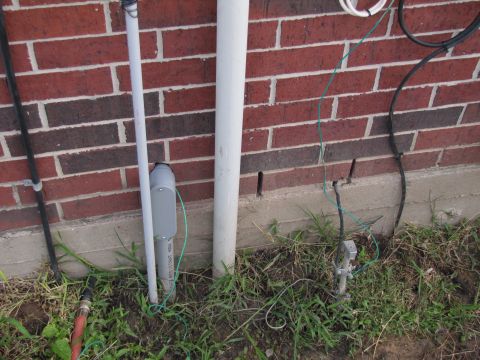 1995 Ford Bronco - Exterior view of electrical conduit, grounding rod, and wiring connected to a brick building.