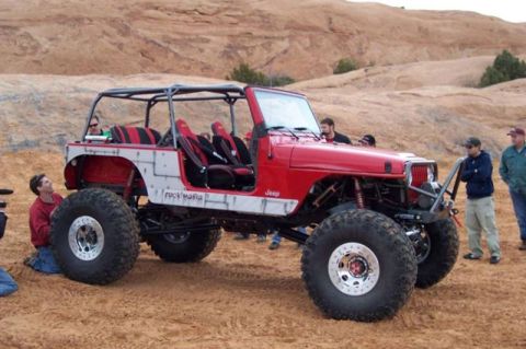 1985 Jeep CJ7 - This heavily modified Jeep CJ7 features a custom roll cage, oversized off-road tires, and a 'Rock'n'Mafia' decal on its side.
