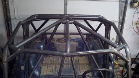 1985 Jeep CJ7 - A custom roll cage is being welded and installed inside a vehicle's interior.