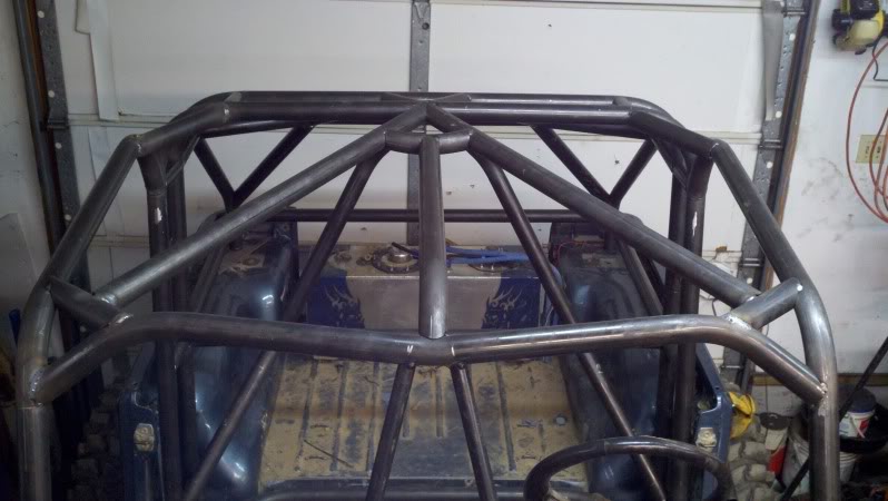 custom roll cage being installed inside a vehicle, showing the interior and fuel tank