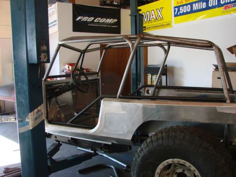1985 Jeep CJ7 - This Jeep CJ-series body is undergoing custom fabrication, a prominent roll cage and bare metal construction.