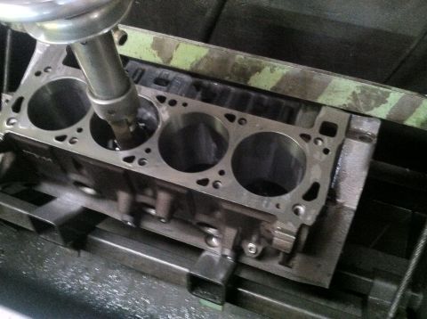 1978 Ford Bronco - A close-up view of an engine cylinder block undergoing machining on a specialized tool.