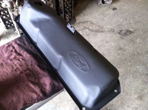 1978 Ford Bronco - A black Ford valve cover is shown, likely a replacement part, with the Ford logo embossed on its surface.