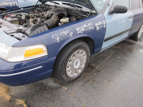 2001 Ford Crown Victoria - A 2001 Ford Crown Victoria with mismatched paint colors and peeling clear coat is shown with its hood open.