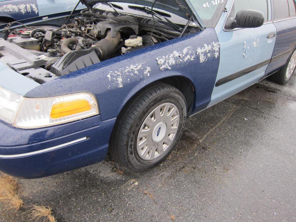 Blue and light blue 2001 Ford Crown Victoria with peeling paint, hood open, showing engine