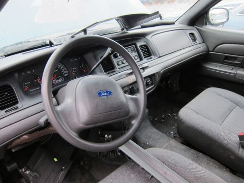 2001 Ford Crown Victoria - The interior of a 2001 Ford Crown Victoria, its dashboard, steering wheel, and seating.